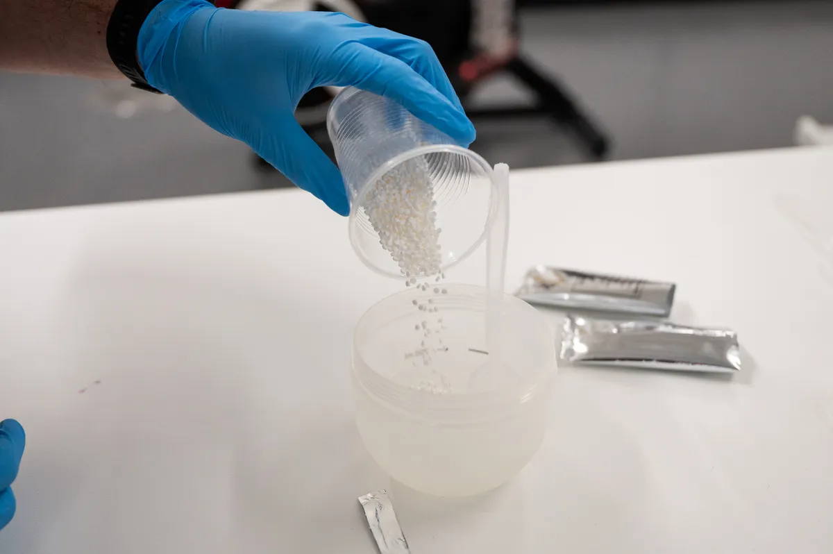 Scientist pouring out sachet of Maurten Bicarb System